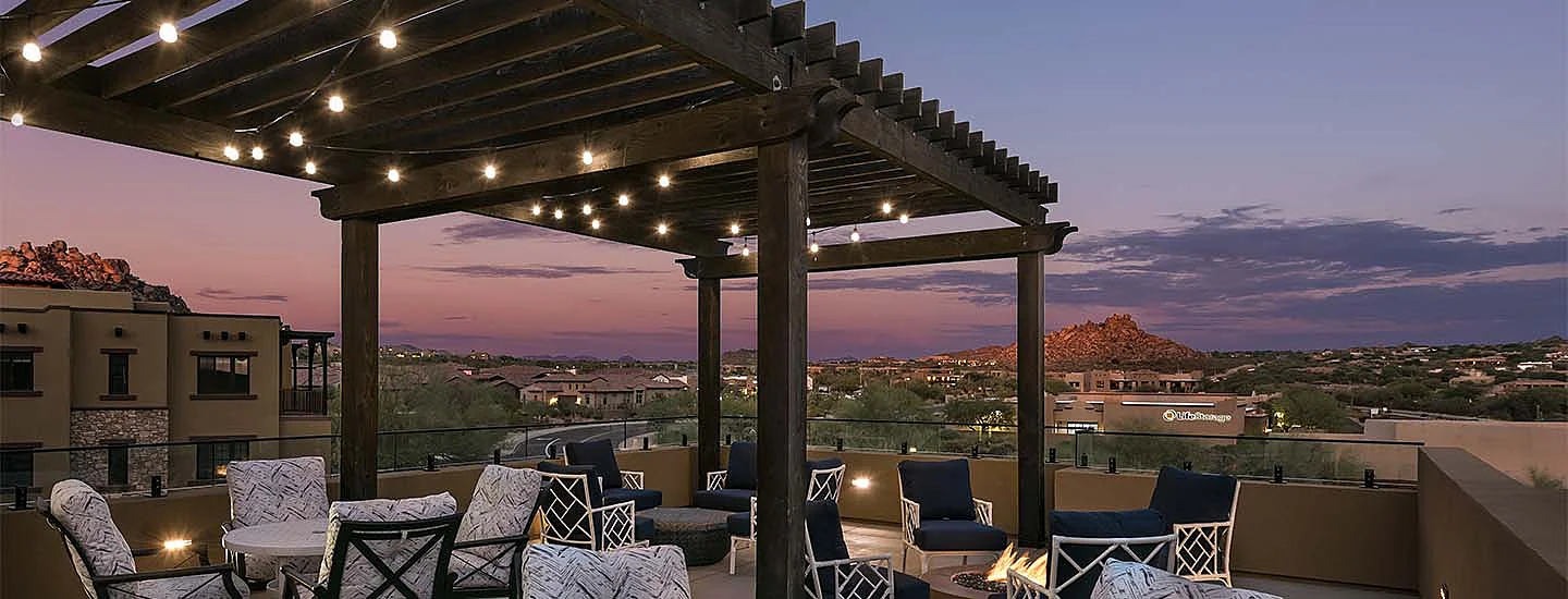 Rooftop lounge against a desert sunset and the mountains at ACOYA Troon