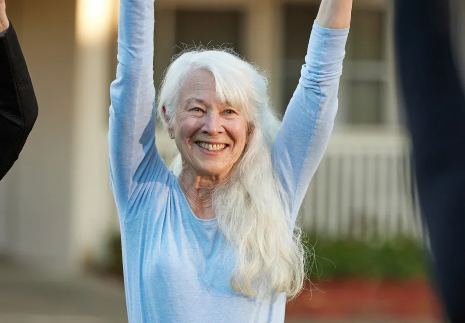 Senior woman stretching during an outdoor fitness class.