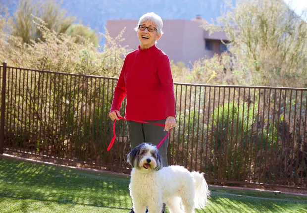 Senior woman walking her fluffy dog.