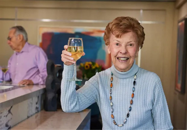 Senior woman raised her white wine glass.
