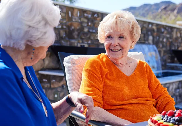Assisted Living residents smile while lounging in the sun.