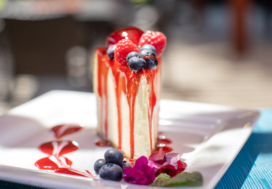 close up of a slice of cheesecake with berries on top