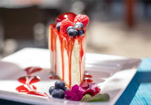 A large slice of cheesecake with berries on top.