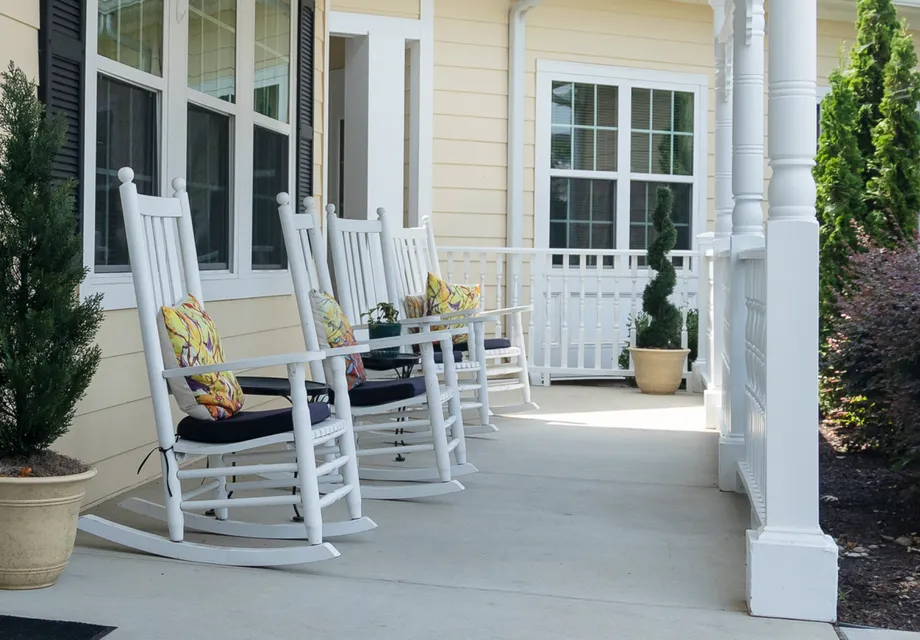Cadence Garner by Cogir's open patio with white rocking chairs.