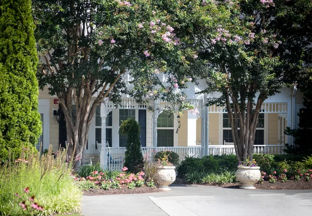 Senior Living in Raleigh with two mature trees around the entrance and walking path