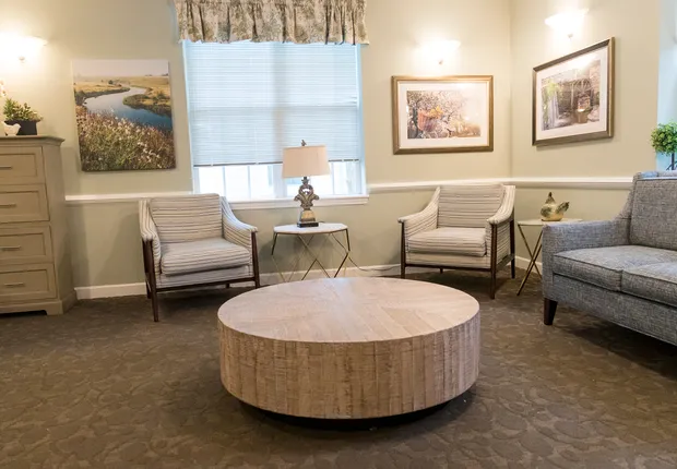 Senior Living in Wake Forest with a round coffee table and two chairs under a window.