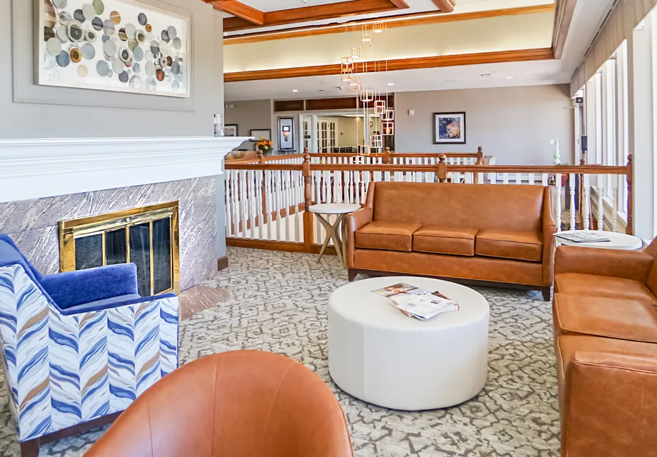 Senior Living in Denver with plush seating by the fireplace.