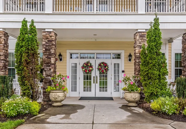 Senior living in Huntersville, large double doors and a tree-lined entrance