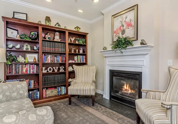 Senior Living in Wake Forest with a cozy library and a fireplace.