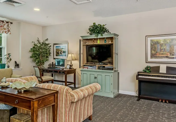 Senior living in Huntersville with a cozy lobby with a TV and piano