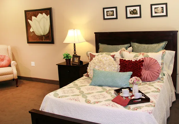 Senior Living in Ogden, UT with a queen-sized bed in an apartment.