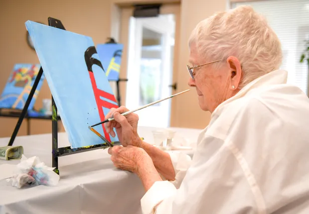 A senior woman painting.