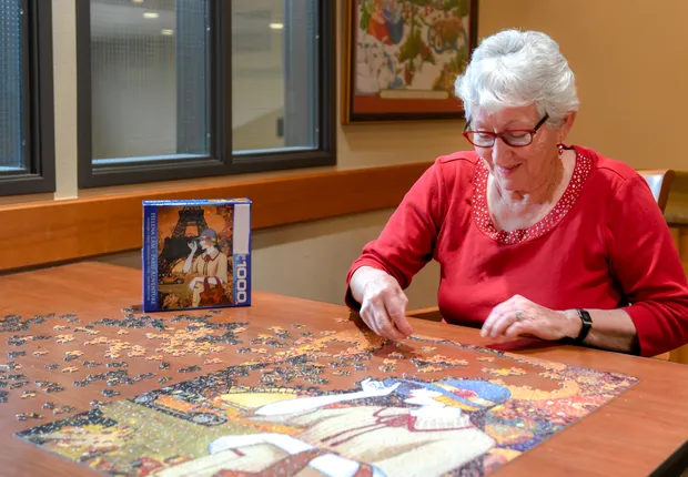A senior woman putting together a puzzle