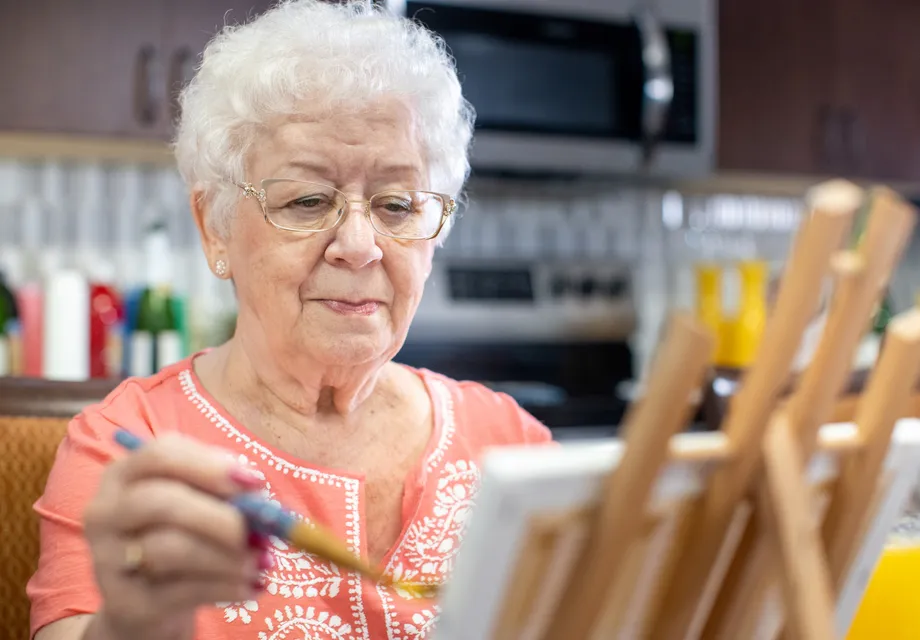 Senior woman paints during a senior art program