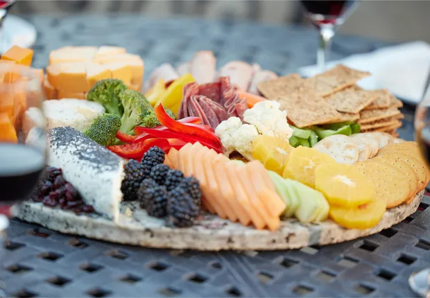 A beautiful charcutterie board with cheese, fruit and vegetables.