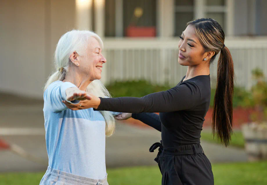 A Cogir staff member guiding a senior woman through the fitness program.