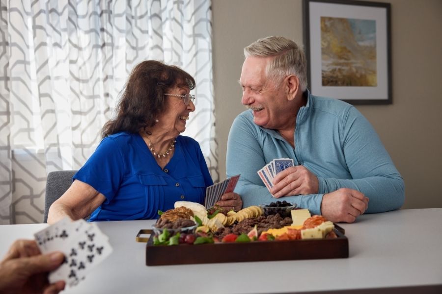 senior couple smiling and playing cards