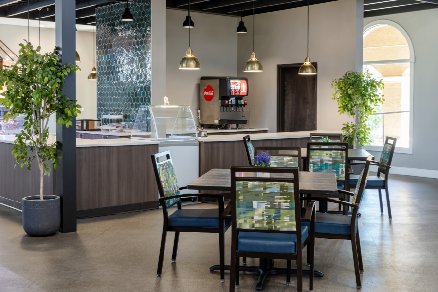 Modern bistro area with dining tables, beverage station, and contemporary decor at Park Terrace Senior Living in Phoenix, AZ.