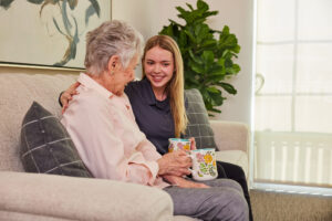 employee smiling and helping an elder