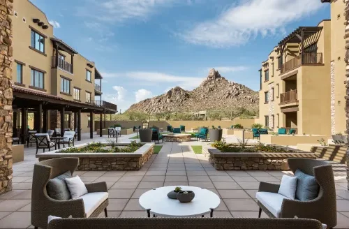 An inviting courtyard surrounded by charming residences, showcasing stunning mountain views, perfect for relaxation.