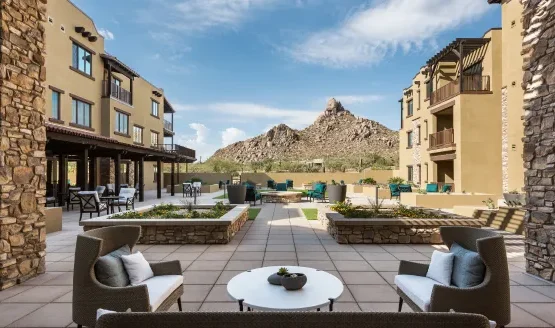 An inviting courtyard surrounded by charming residences, showcasing stunning mountain views, perfect for relaxation.