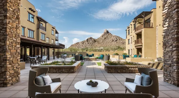 An inviting courtyard surrounded by charming residences, showcasing stunning mountain views, perfect for relaxation.