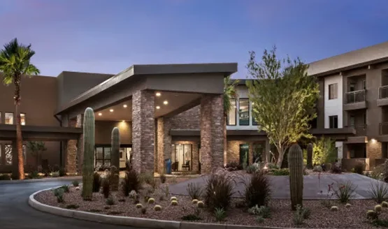 A welcoming entrance adorned with lush greenery and modern architecture, inviting community connections.