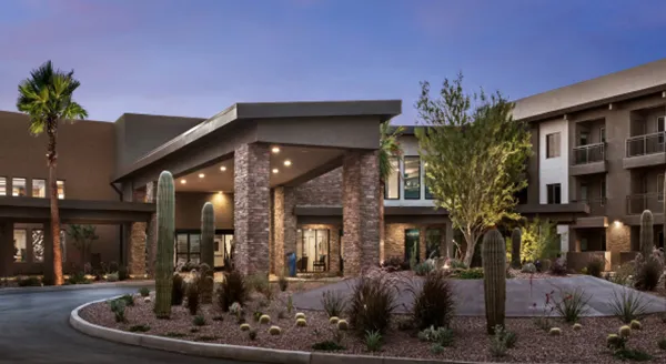 A welcoming entrance adorned with lush greenery and modern architecture, inviting community connections.
