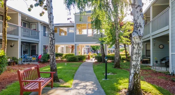 A inviting green courtyard features comfortable seating and inviting pathways, promoting community and connection.