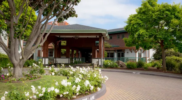 Nestled among vibrant gardens, the welcoming entrance invites residents to a warm community atmosphere.