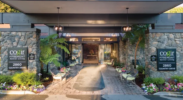 A warm welcome awaits at this inviting entrance, showcasing a beautifully landscaped path and cozy seating areas.