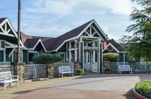 Welcoming entrance with inviting benches, lush greenery, and a bright, friendly atmosphere.
