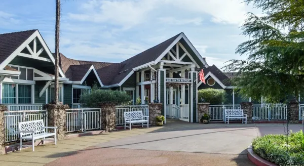 Welcoming entrance with inviting benches, lush greenery, and a bright, friendly atmosphere.