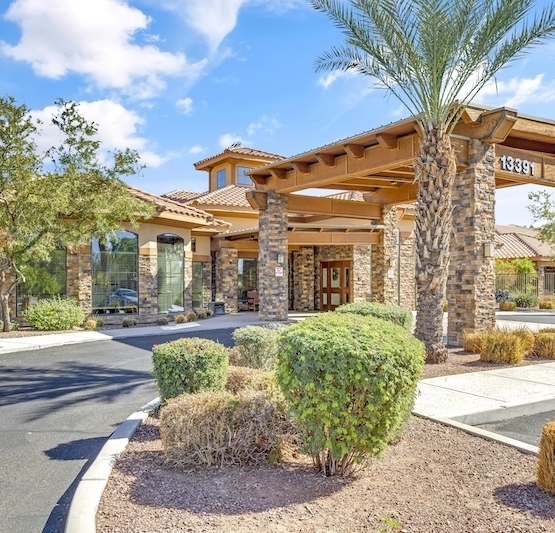 Welcoming entrance surrounded by greenery, inviting sunlight, and a sense of community at the forefront.