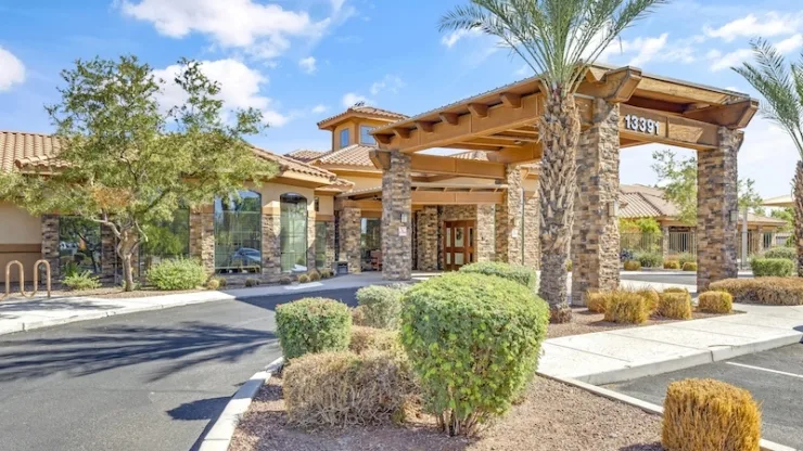 Welcoming entrance surrounded by greenery, inviting sunlight, and a sense of community at the forefront.