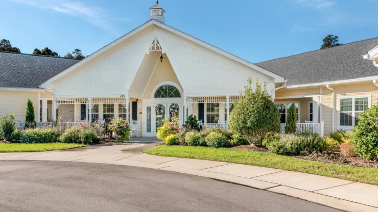 A welcoming entrance surrounded by vibrant gardens, evoking community and comfort for residents.