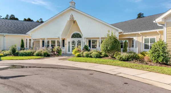 A welcoming entrance surrounded by vibrant gardens, inviting community warmth and comfort.