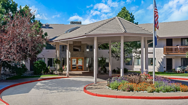 Welcoming entrance surrounded by vibrant flowers and a serene atmosphere, inviting community living.