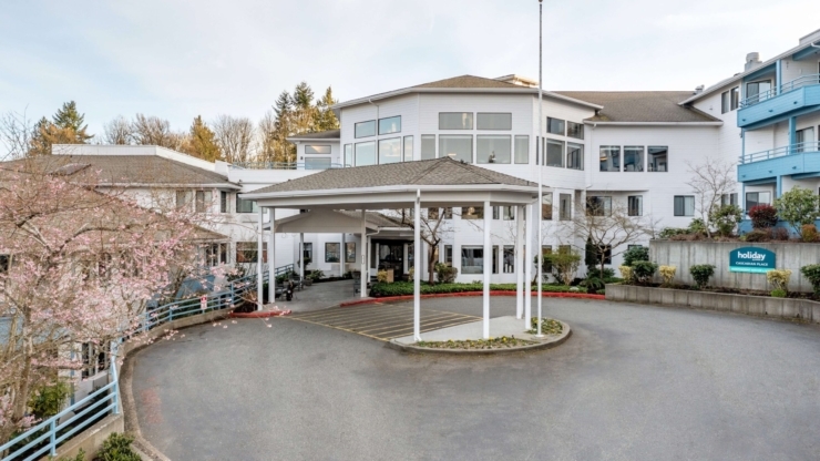 A welcoming community entrance surrounded by blooming trees, inviting residents and families.