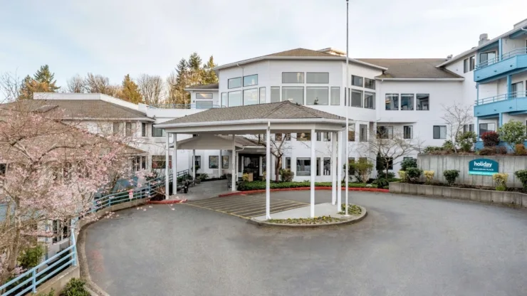 A welcoming community entrance surrounded by blooming trees, inviting residents and families.