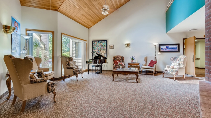 Inviting common area featuring comfortable seating, natural light, and a piano, perfect for community gatherings.