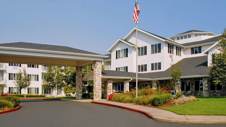 A welcoming entrance showcases beautiful gardens and comfortable, inviting architecture, perfect for community.