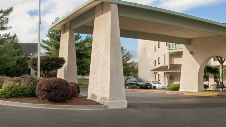 A welcoming entrance with lush greenery, inviting residents and families to enjoy a supportive community.