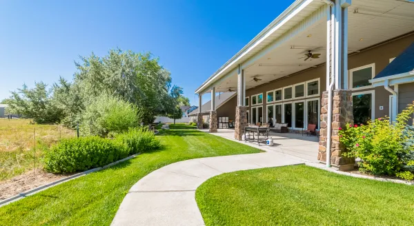 A welcoming outdoor space with vibrant gardens and a sunlit patio invites relaxation and community connection.