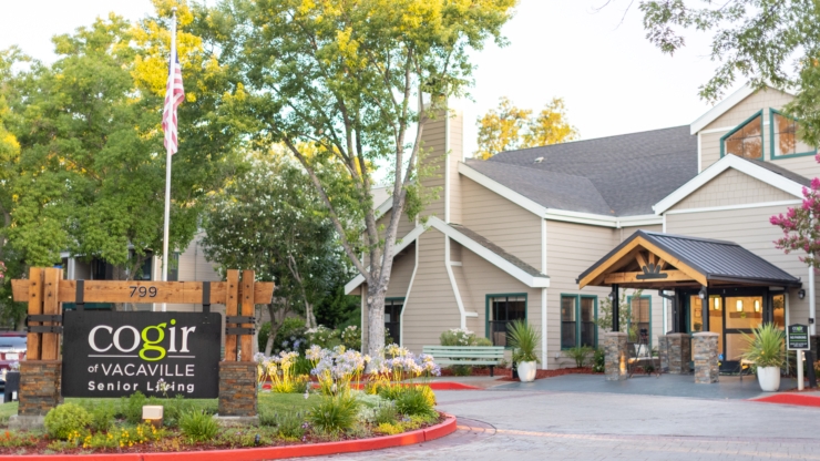 Warmly inviting entrance surrounded by lush greenery, promoting a sense of community and comfort.