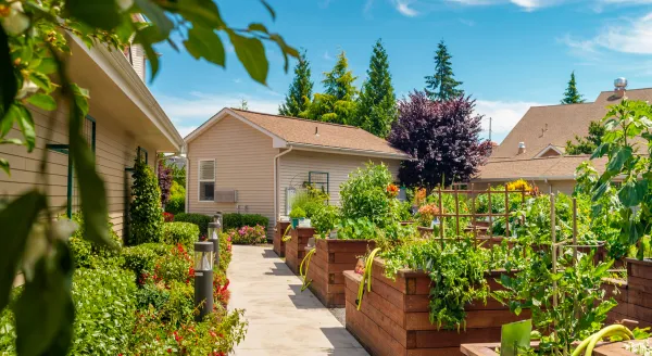 A vibrant garden path, filled with lush greenery, invites residents to enjoy nature and community.