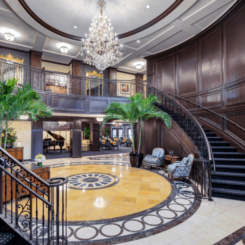 An inviting lobby features elegant decor, lush plants, and cozy seating, fostering warmth and community.