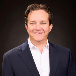 A welcoming smile conveys warmth and professionalism, reflecting a supportive community atmosphere.