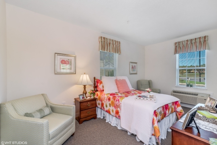 A bright, inviting room features floral decor, comfortable seating, and personal touches, fostering community and warmth.