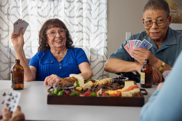 Lively laughter fills the air as friends enjoy card games and delightful snacks in a warm, inviting space.